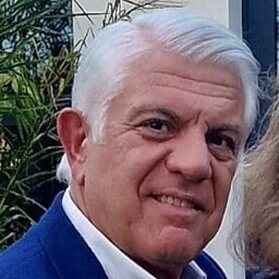 foto de rafael díaz nava, pelo canoso, chaqueta azul marino y camis blanca