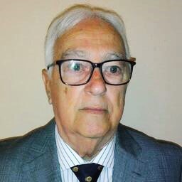 foto de sergio jiménez, con gafas, pelo canoso, chaqueta gris, camisa blanca y corbata azul marino