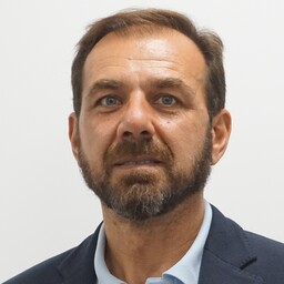 foto de alberto bichara. Lleva chaqueta azul marino y camisa azul claro